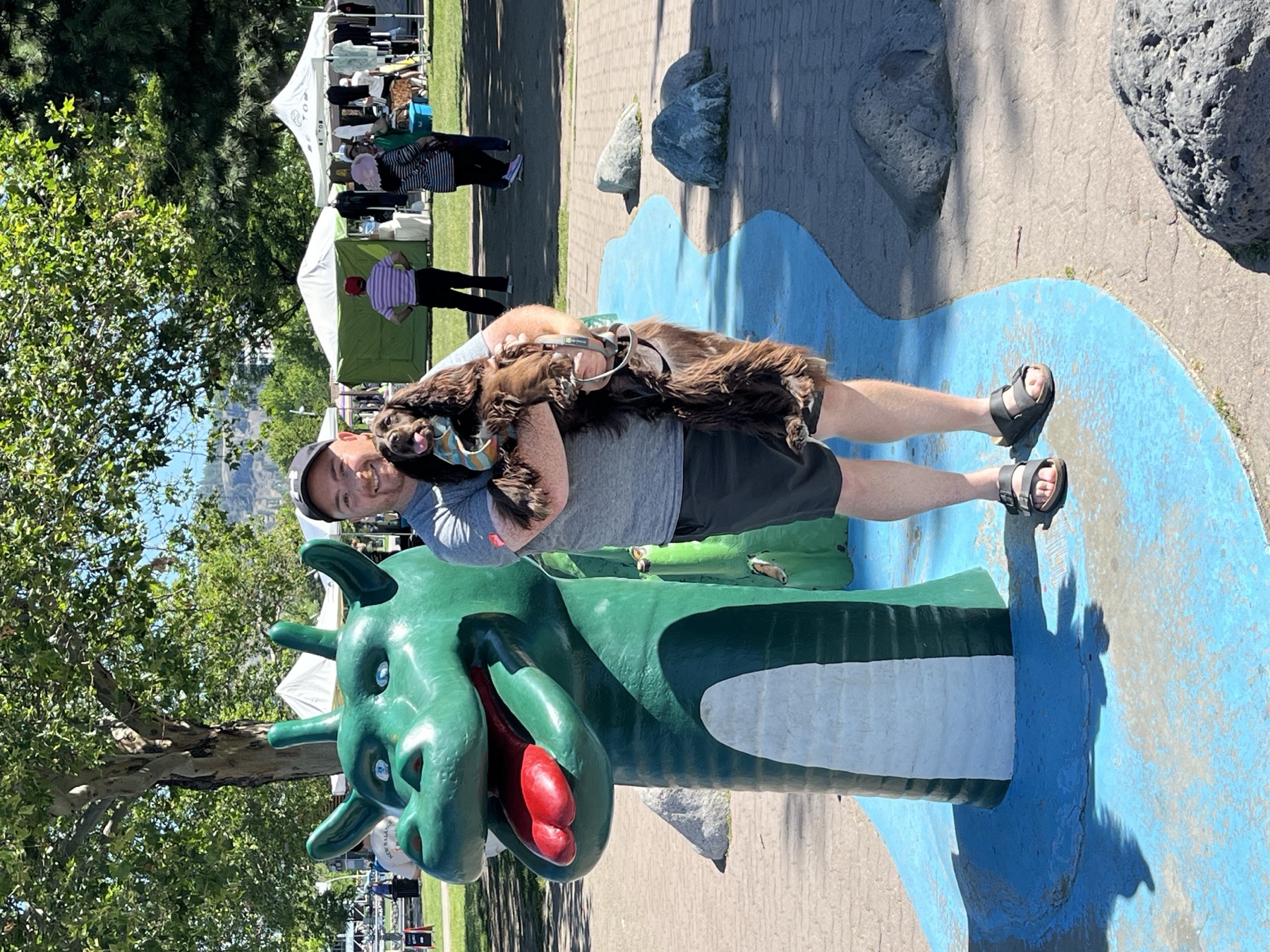 Tilly and Shaun beside the green Ogopogo figure on Kelowna's waterfront