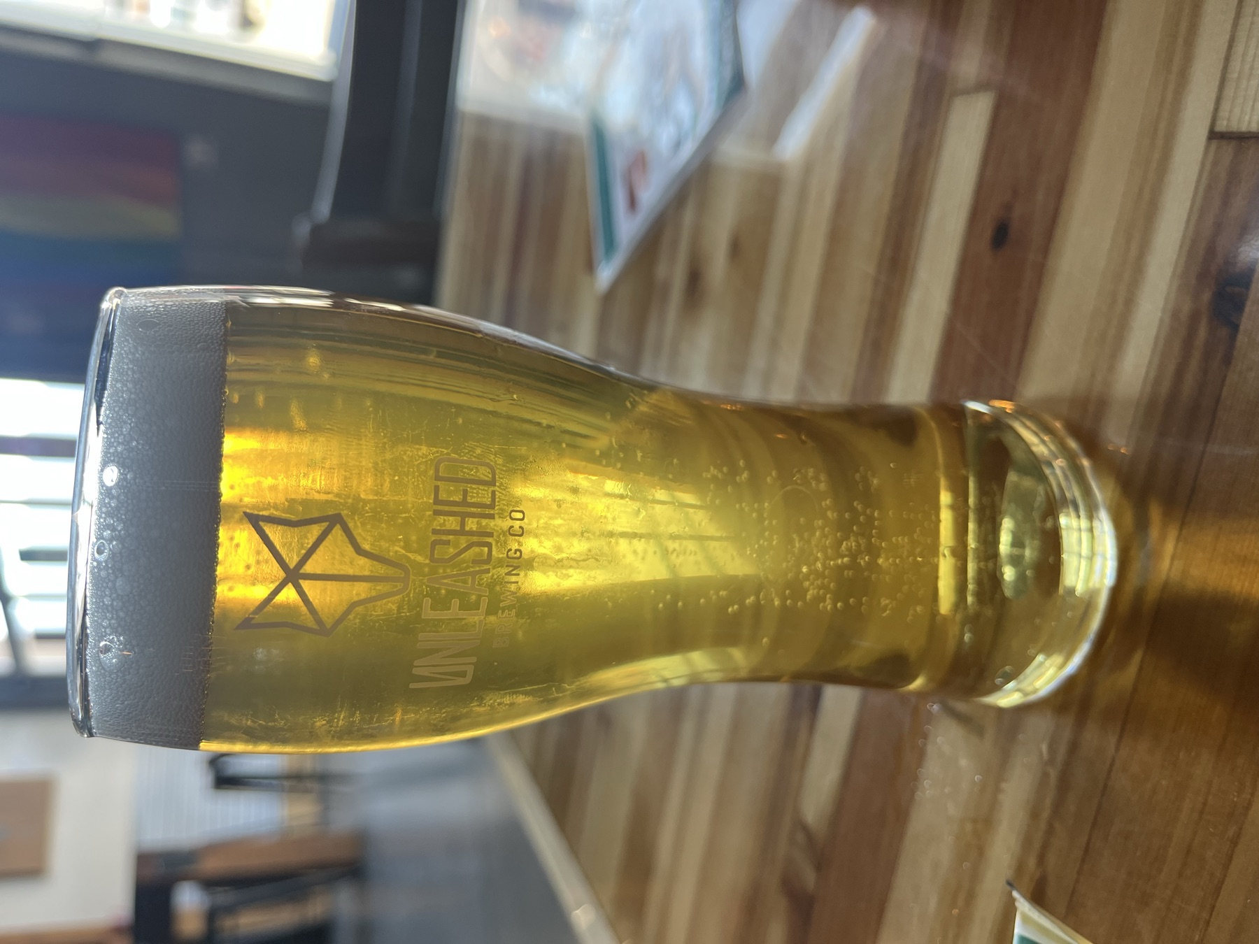 A glass of beer carrying the Unleashed Brewing logo