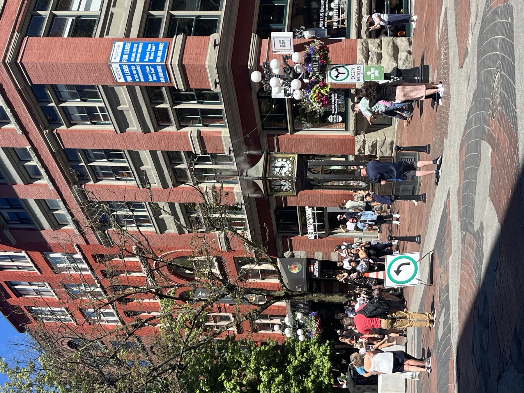 The Gastown Steam Clock surrounded by visitors and brick buildings