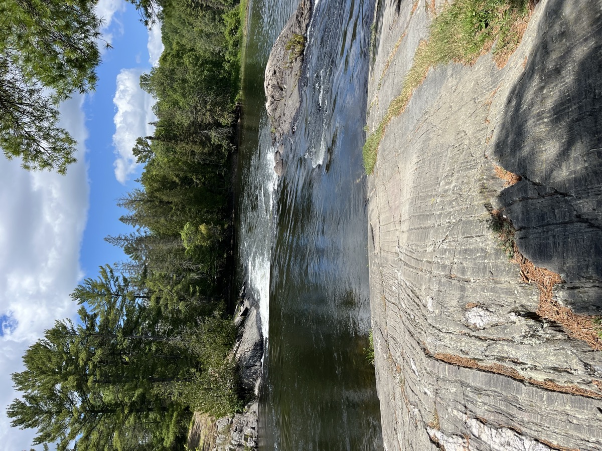 The Serpent River flowing between rocky forested banks