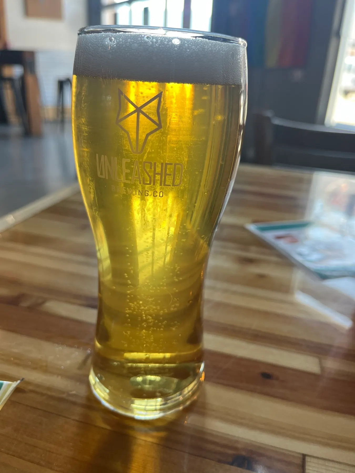 Un verre de bière portant le logo d’Unleashed Brewing