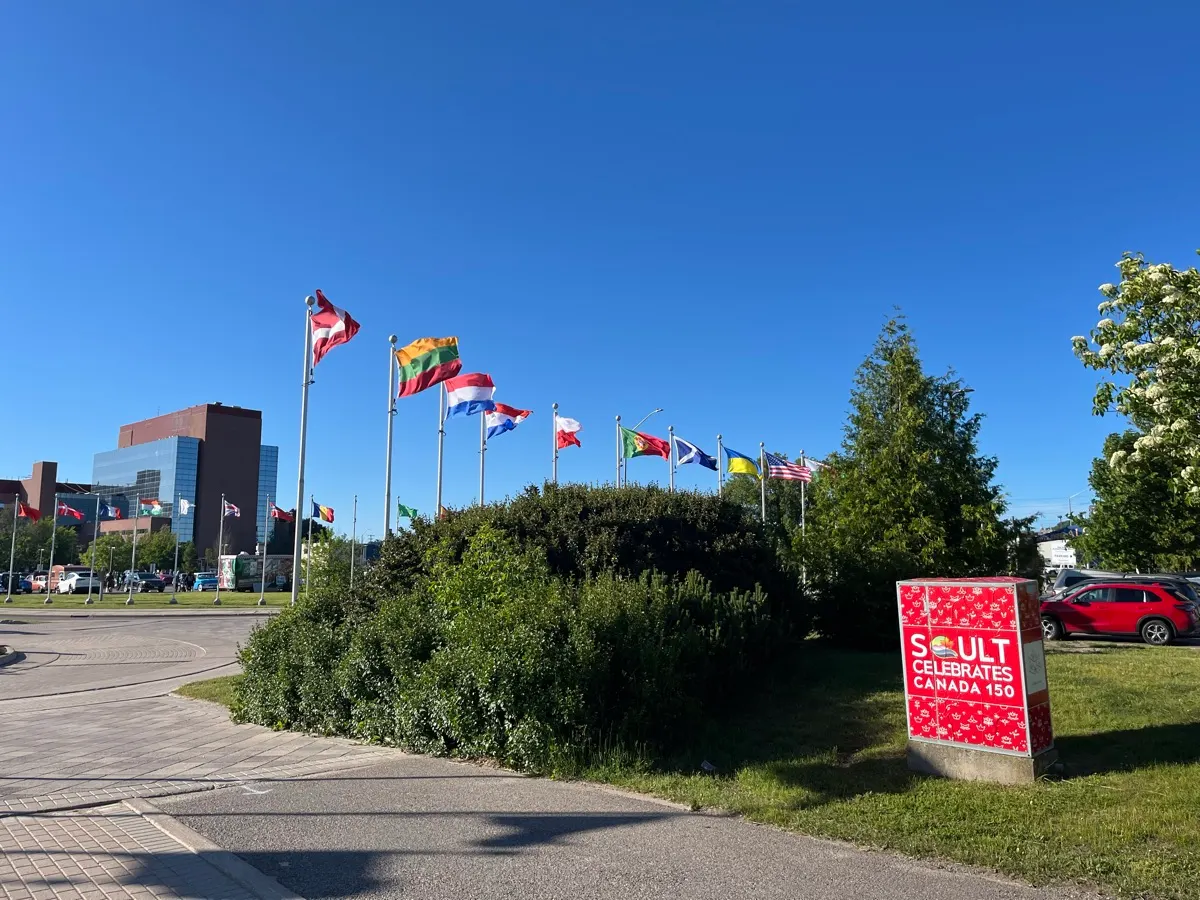 Des drapeaux internationaux flottant à côté du parc à Sault Ste. Marie