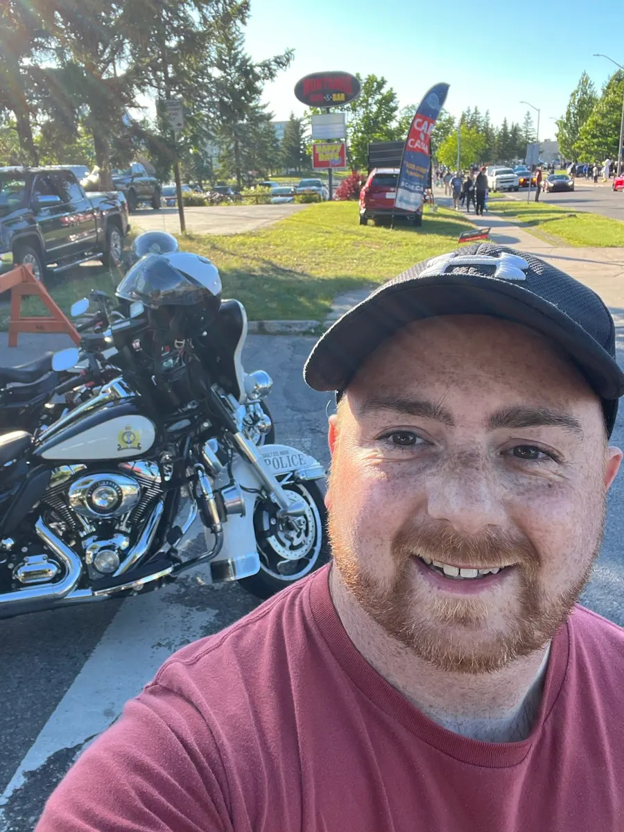 Shaun à côté d’une moto de police à l’événement de voitures anciennes