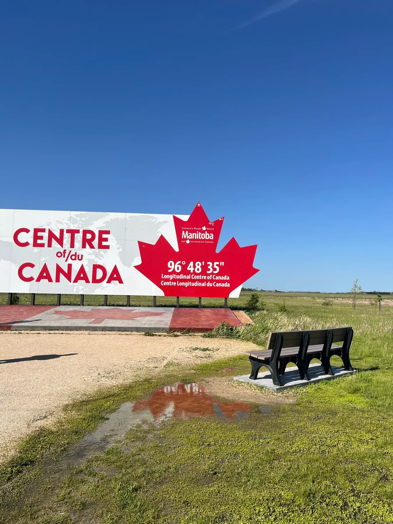 Le panneau du centre longitudinal du Canada sous un vaste ciel de prairie
