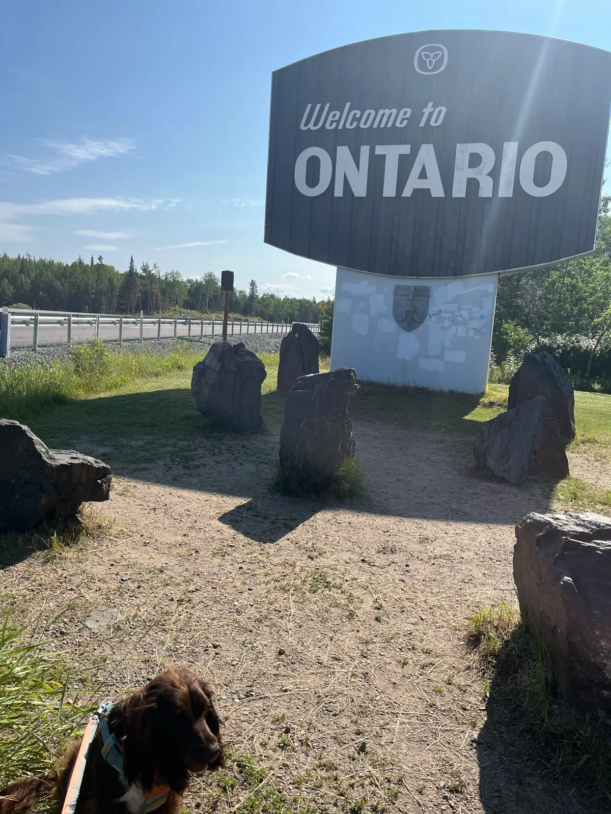 Tilly à côté du panneau Welcome to Ontario à la frontière du Manitoba