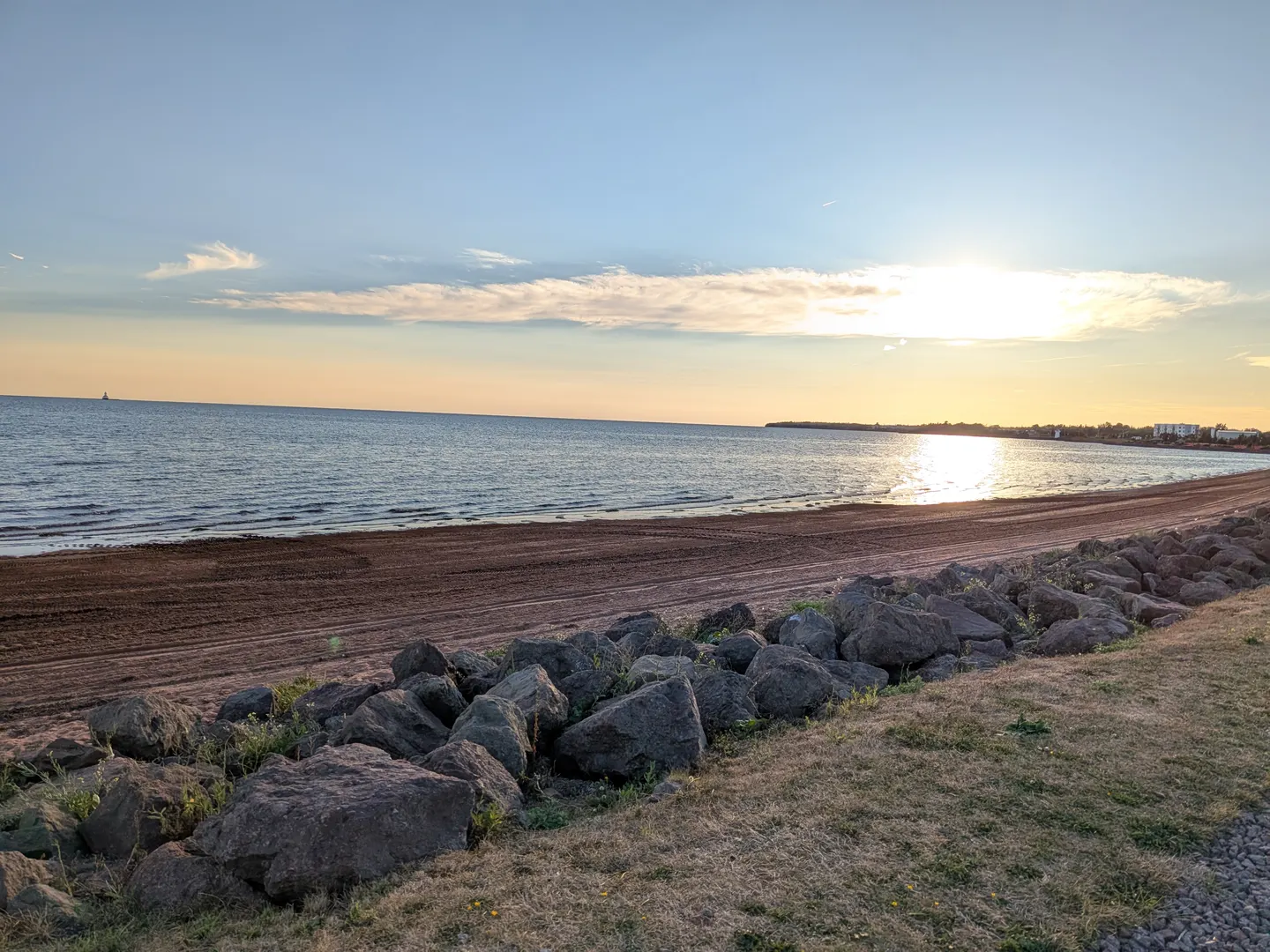 Le coucher du soleil sur le rivage à la promenade Baywalk de Summerside